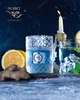 A candle with a Moscow Mule theme, surrounded by ingredients like lemon and ginger, with a lit candle and a drink in the background. Voir les images du produit