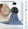 A blue blanket is draped over an open washing machine, with washing instructions displayed on the right side of the image. Produktbild-Vorschau