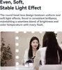 A woman is applying makeup in front of a lighted mirror. Produktbild-Vorschau