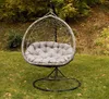 A gray hanging egg chair with a cushion sits on a grassy lawn in front of trees with autumn foliage. Voir les images du produit