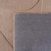 A close-up view of a rug, showing the texture of the material and the edge where the top and bottom layers meet. Produktbild-Vorschau