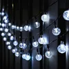 A string of solar-powered globe lights with a textured, frosted appearance, hanging outdoors at night against a dark background. Produktbild-Vorschau