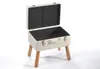 A white suitcase-shaped stool with wooden legs on a white background. Náhled obrázku produktu