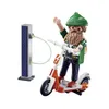 A Playmobil figure of a hipster with a beard and green hat, riding an electric scooter, connected to a solar-powered charging station. Anteprima dell’immagine prodotto