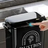 A hand is shown pressing a button on a black trash can next to a kitchen sink. Produktbild-Vorschau