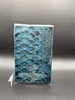 The image shows the back of a perfume box with a blue, scaly pattern. Náhled obrázku produktu