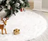 A white fluffy Christmas tree skirt with a reindeer decoration and a gift box. Produktbild-Vorschau