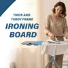 A woman is ironing clothes on an ironing board in a well-lit room. Produktbild-Vorschau