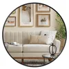 A round mirror reflects a living room scene with a sofa, artwork, and a plant. Produktbild-Vorschau