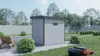 A modern WPC garden shed is shown in a backyard setting, next to a lawnmower and lounge chair. Produktbild-Vorschau