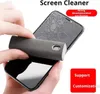 A hand is cleaning a smartphone screen with a screen cleaner spray bottle that also functions as a wiping cloth. Produktbild-Vorschau