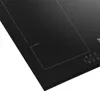 A close-up view of a black induction hob. Voir les images du produit