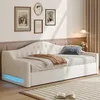 A white upholstered daybed with a throw blanket and a pillow, set in a room with framed pictures on the wall and curtains. Náhled obrázku produktu