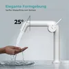A white faucet with water flowing into a hand, demonstrating its design and water flow. The background is a light gray gradient. Produktbild-Vorschau