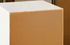 Close-up view of the back panel of a white cabinet or furniture piece, showing the particleboard and its unfinished edge. Produktbild-Vorschau