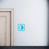 A close-up of a door and a wall with a blue icon on it. Náhled obrázku produktu