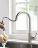 A person is using a kitchen faucet to rinse a sponge in a sink, with a window in the background. Produktbild-Vorschau