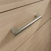 A close-up view of a modern silver handle attached to a light wood drawer. Produktbild-Vorschau