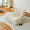 A comfortable beige armchair on a rug in a well-lit room. Produktbild-Vorschau