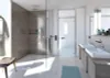 A modern bathroom with a walk-in shower, double vanity, and a bathrobe hanging on a hook. Voir les images du produit