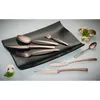 A set of bronze-colored cutlery arranged on a black plate, with mushrooms and parsley as decoration. Produktbild-Vorschau