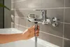 A hand is shown attaching a shower hose to a bathtub faucet. Anteprima dell’immagine prodotto