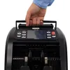 A hand holding the handle of a black money counting machine. Produktbild-Vorschau