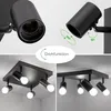 A collage of images showing a black ceiling light fixture with adjustable spotlights, demonstrating its rotation and tilt features, and showing the fixture installed on a ceiling. Voir les images du produit