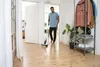 A man is using a cleaning device on a wooden floor in a hallway. Anteprima dell’immagine prodotto
