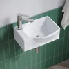 A white corner sink with a silver faucet mounted on a green tiled wall. Produktbild-Vorschau