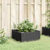 Two black planters with plants in them are placed on a grassy lawn in front of a wooden fence. Produktbild-Vorschau