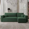 A modern living room with a green sectional sofa, a chandelier, and curtains. Produktbild-Vorschau