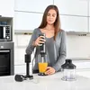 A woman is using an immersion blender in a modern kitchen. Podgląd zdjęcia produktu
