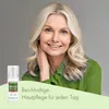 A woman is smiling and touching her neck, with a product bottle in the lower left corner and text overlay. Produktbild-Vorschau