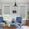 A living room scene with two chairs, a coffee table, and windows with blinds. Produktbild-Vorschau
