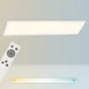 A white LED panel light with a remote control is shown against a light gray and white background, with a brick pattern at the bottom. Náhľad obrázku produktu