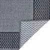 A close-up view of a rug, showing its texture and pattern. The rug is folded in one corner, revealing the underside. Produktbild-Vorschau