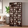 A tall, dark brown wooden bookshelf filled with CDs and decorative items, standing against a light gray wall next to a sofa and a plant. Produktbild-Vorschau