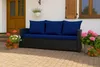 A dark rattan sofa with blue cushions sits on a paved patio, surrounded by potted plants. Produktbild-Vorschau