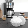 A coffee maker with coffee filters, coffee beans, and a cup of coffee. Produktbild-Vorschau