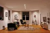A modern living room with a sofa, armchair, coffee table, and entertainment center. Produktbild-Vorschau