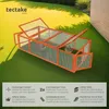 A wooden rabbit hutch with two rabbits inside, placed on artificial grass in a garden setting. Produktbild-Vorschau