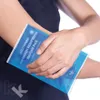 A person is holding a hot/cold pack to their arm. Produktbild-Vorschau