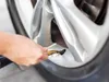 A person's hand is shown holding an air chuck to a car tire valve stem. Náhled obrázku produktu