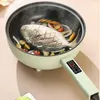 Hellgrüner elektrischer Kochtopf mit Digitalanzeige am Griff, kocht einen ganzen Fisch mit Gemüse Produktbild-Vorschau