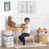 A young boy sits at a wooden desk with a teddy bear and storage boxes nearby, in a child's room setting. Produktbild-Vorschau