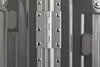 A close-up view of a metal hinge connecting two gray surfaces, likely parts of a suitcase or case. Podgląd zdjęcia produktu