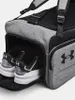 A close-up view of a grey Under Armour duffel bag with a shoe compartment open, revealing a pair of black and white sneakers. Náhled obrázku produktu