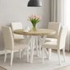 A round dining table with chairs in a dining room setting. Voir les images du produit