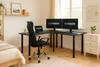 A home office setup with a corner desk, two monitors, a laptop, and an office chair. Produktbild-Vorschau